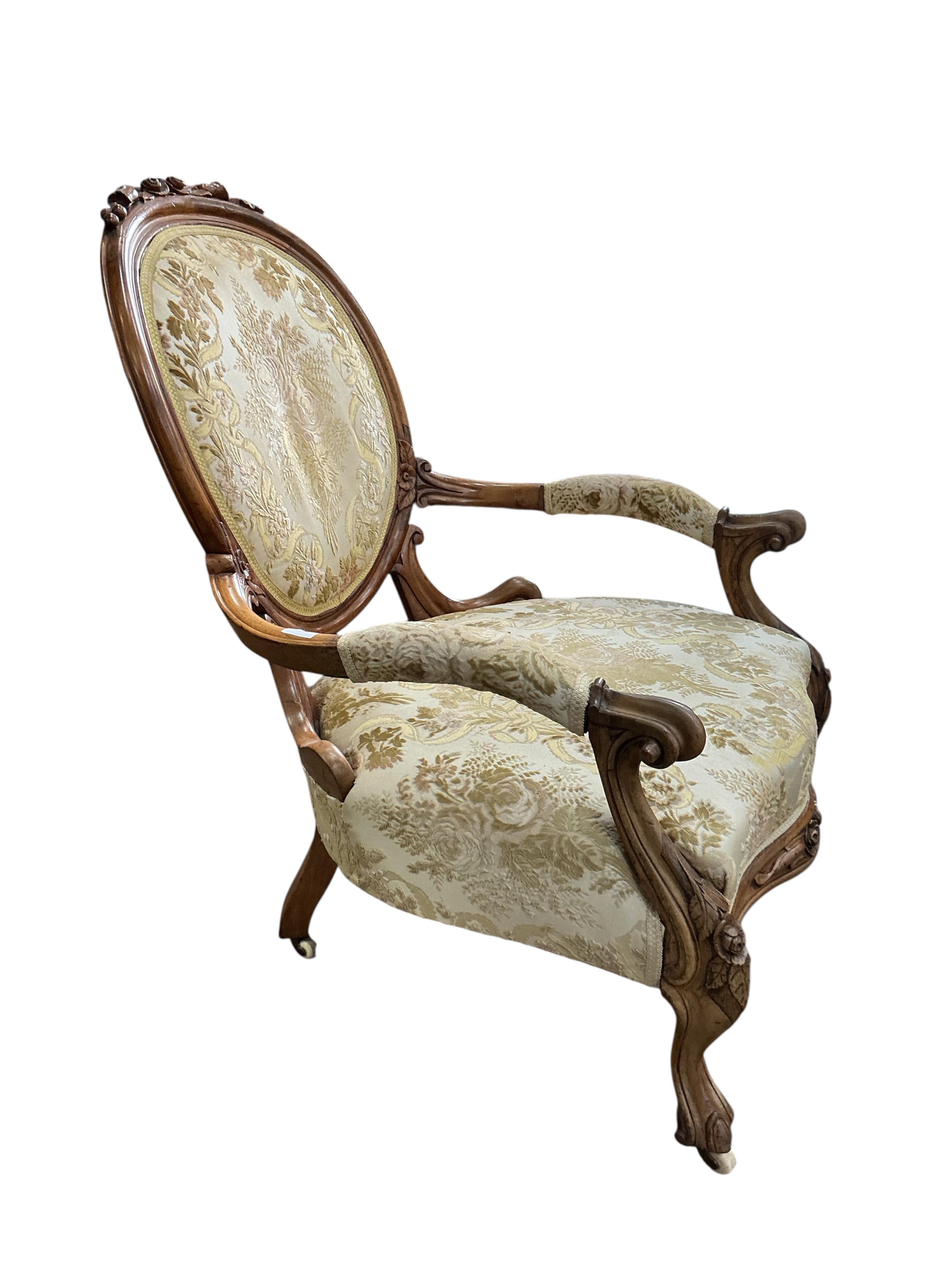 A Victorian faded rosewood spoon back open armchair, width 70cm, depth 62cm, height 100cm